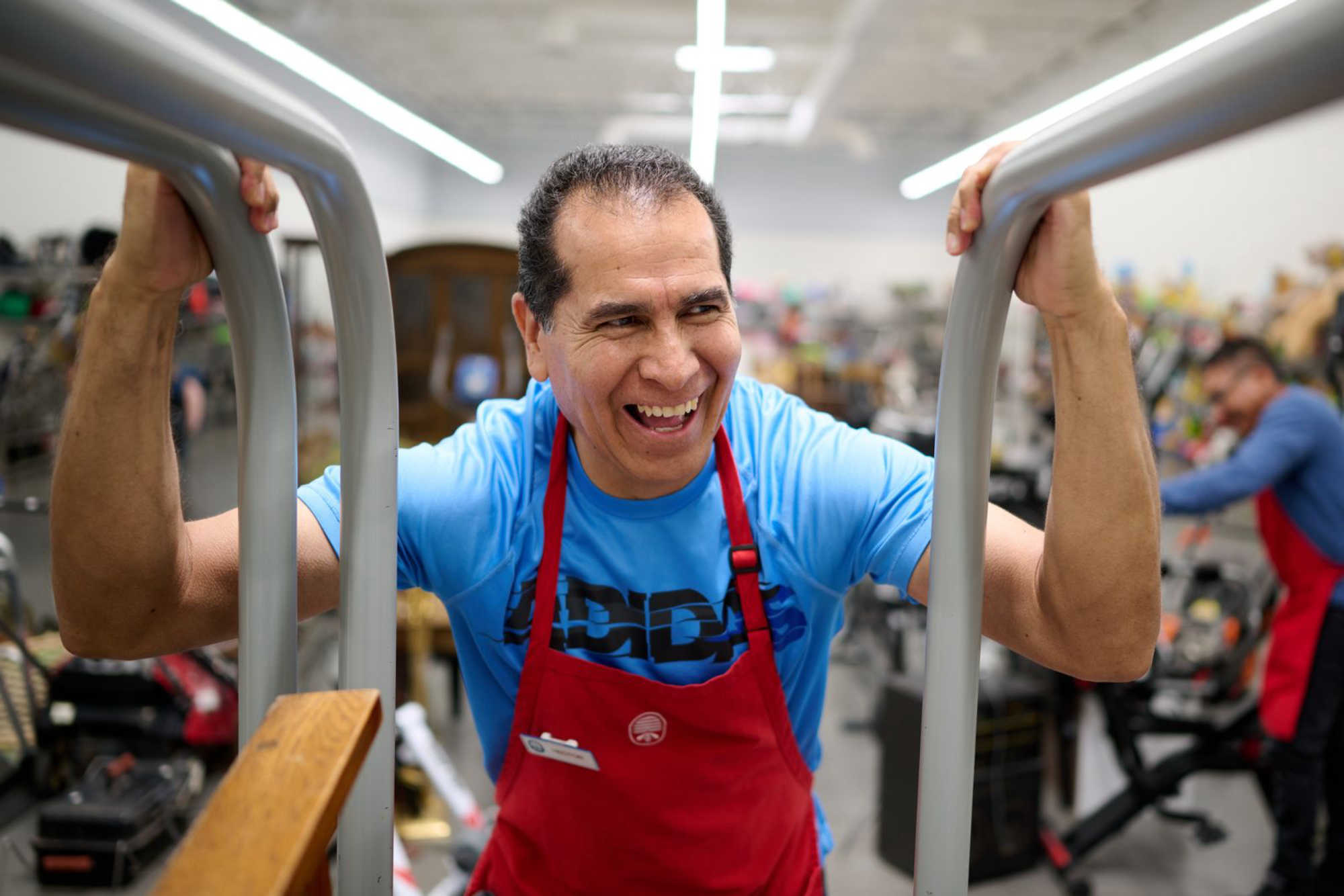 A thrift store worker smiles as he works